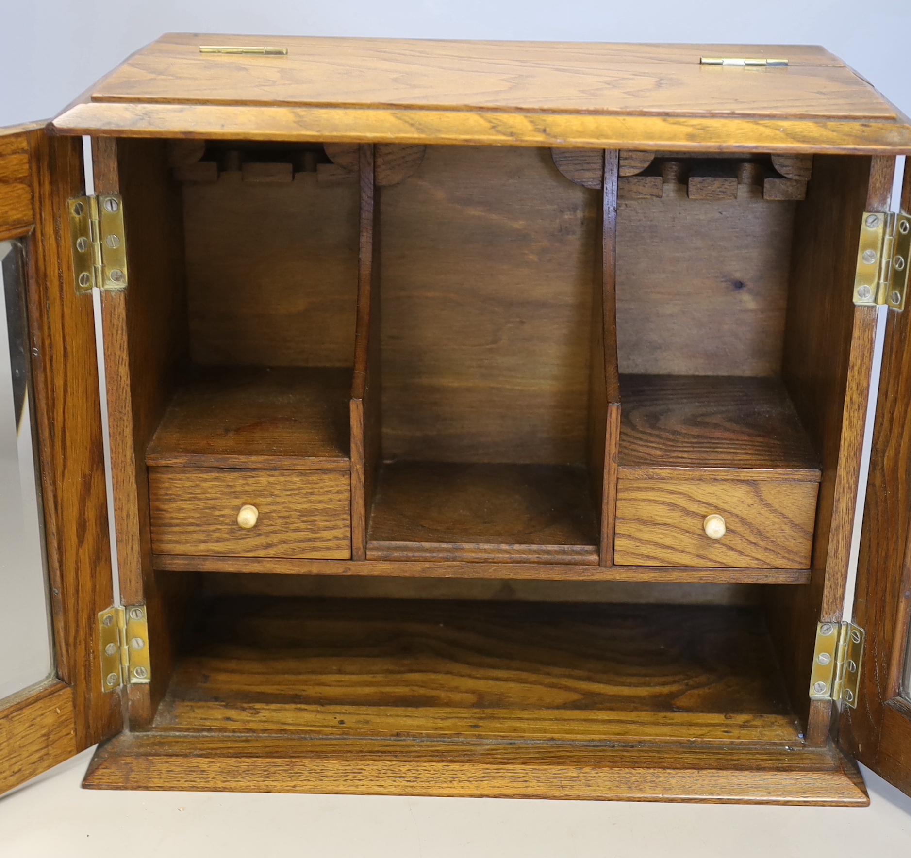 An oak cased smoker’s cabinet with bone handles and brass mounts, 31cm high